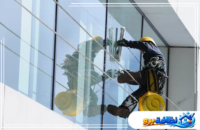 تنظيف واجهات زجاج للفلل في حفر الباطن 547528699 شركة نظافة برو عامل ينظف واجهة زجاجية لمبنى مرتفع باستخدام معدات الحبال المخصصة للتنظيف.